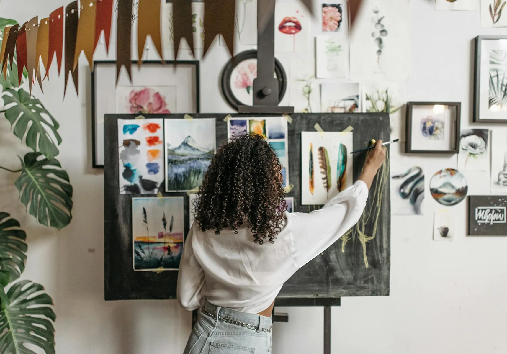 An artist at work among paintings in her studio